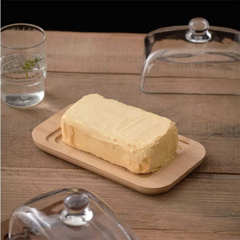 Beurrier transparent avec bouton noir sur fond de table en bois