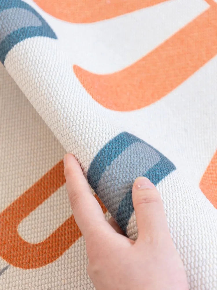 Motif géométrique aux couleurs vives sur un tissu texturé.