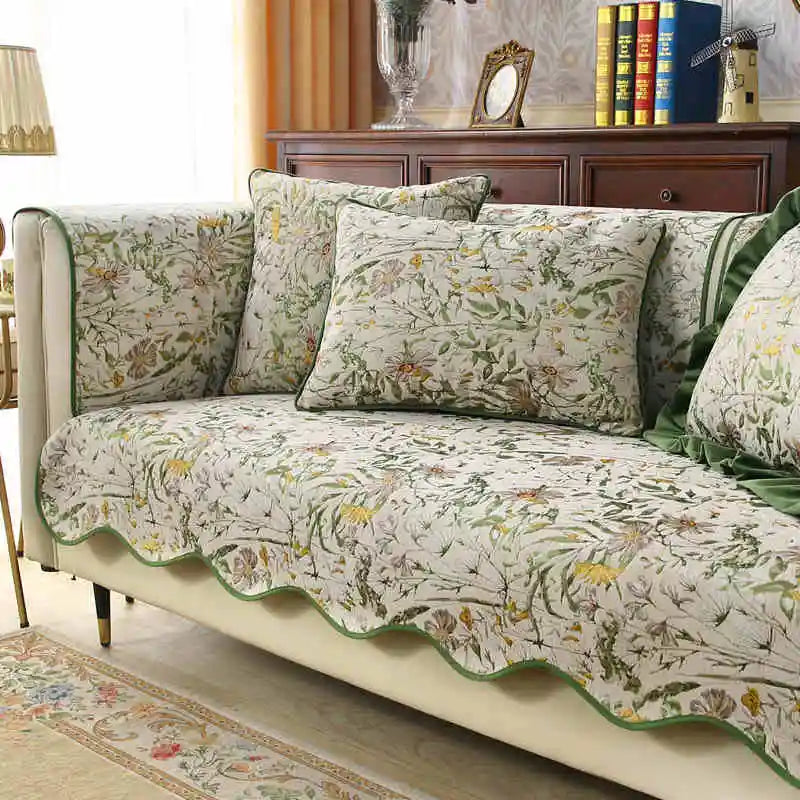 Un canapé recouvert d'un motif floral coloré, avec des coussins assortis, placé dans un salon élégant.