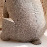 Cale-porte lapin en peluche dans un intérieur cosy avec coussins