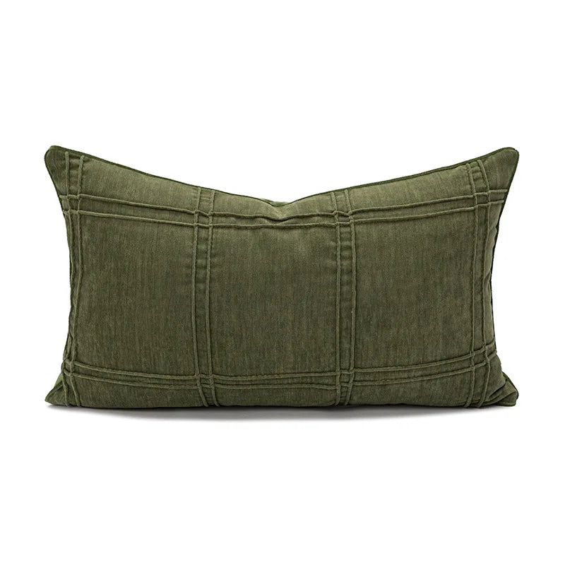 Un coussin rectangulaire en tissu vert militaire, avec des lignes de couture apparentes et un aspect robuste.