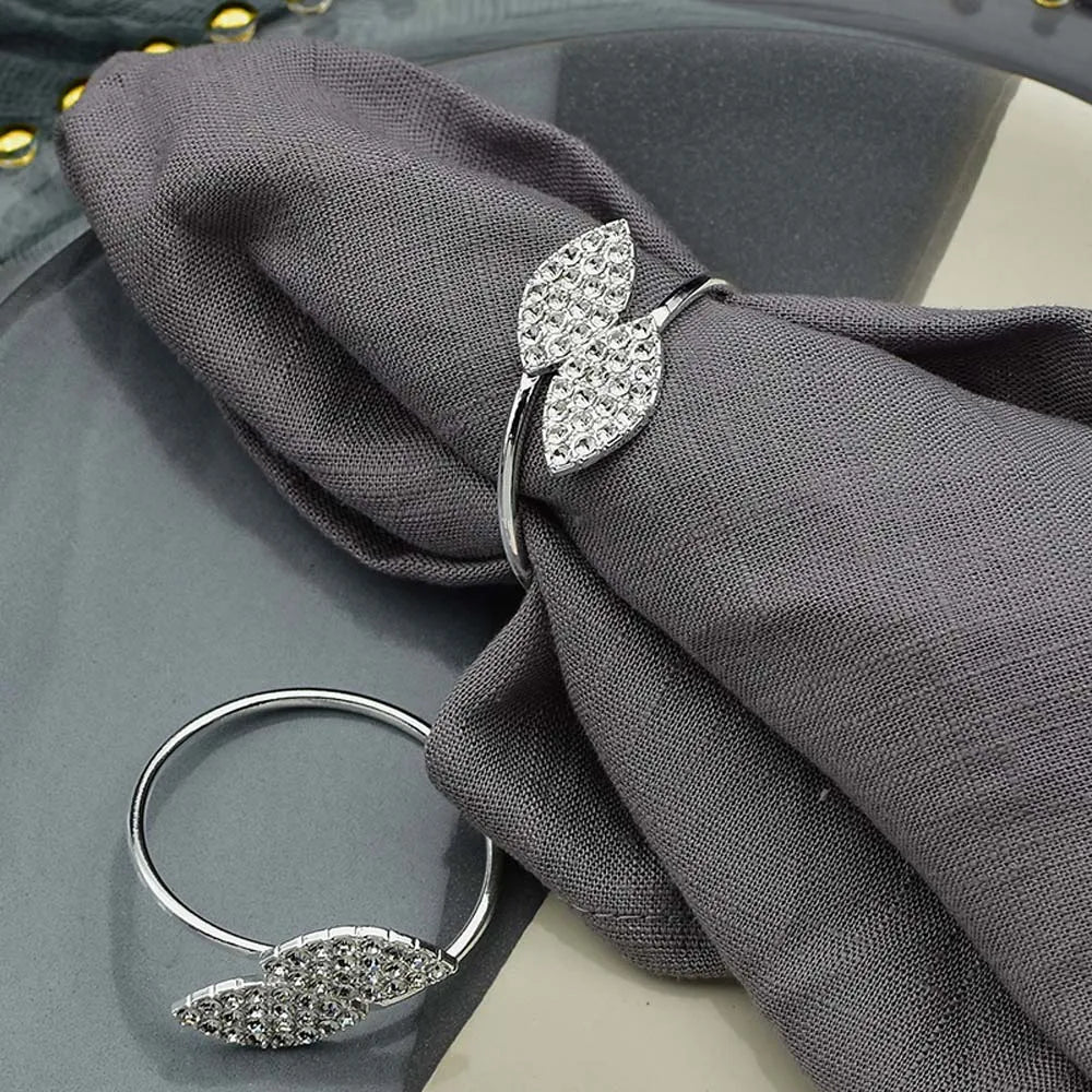 Un élégant anneau en argent orné de cristaux scintillants posé sur un tissu gris foncé.