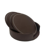 Ensemble de six sous-verres ronds en cuir marron foncé avec coutures blanches apparentes, présentés avec un support pour les ranger élégamment.
