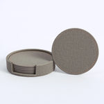 Ensemble de sous-verres ronds en tissu gris foncé avec coutures apparentes.
