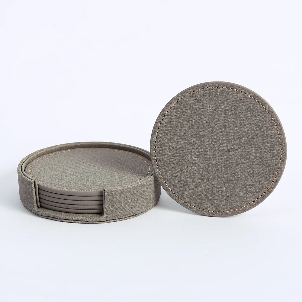 Ensemble de sous-verres ronds en tissu gris foncé avec coutures apparentes.