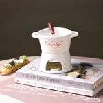 fondue chocolat moderne tasses lait rouge noir blanc cuillère bougie