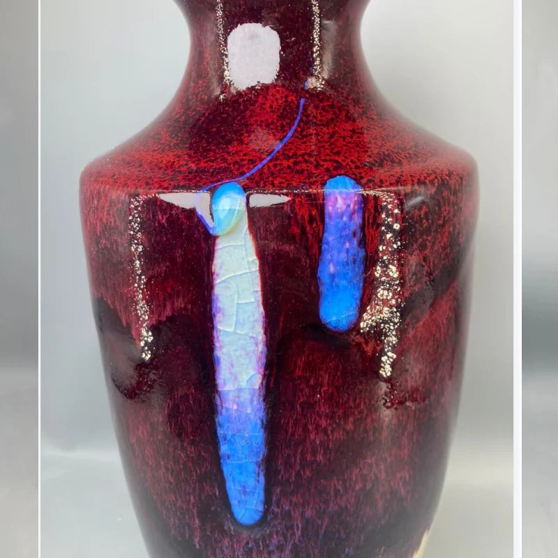 Vase en céramique rouge foncé avec des motifs bleus et blancs irréguliers, créant une texture unique et intéressante.