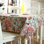 Élégante nappe florale ornée de motifs colorés et dynamiques, donnant à la pièce une atmosphère chaleureuse et invitante.