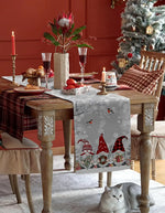 Une table de Noël festive avec de beaux éléments décoratifs, une chaise en bois et un chat gris assis sous la table.