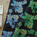 tissu polyester brodé fleurs relief noir vert bleu doré résistant opacité jacquard 165cm fleuri