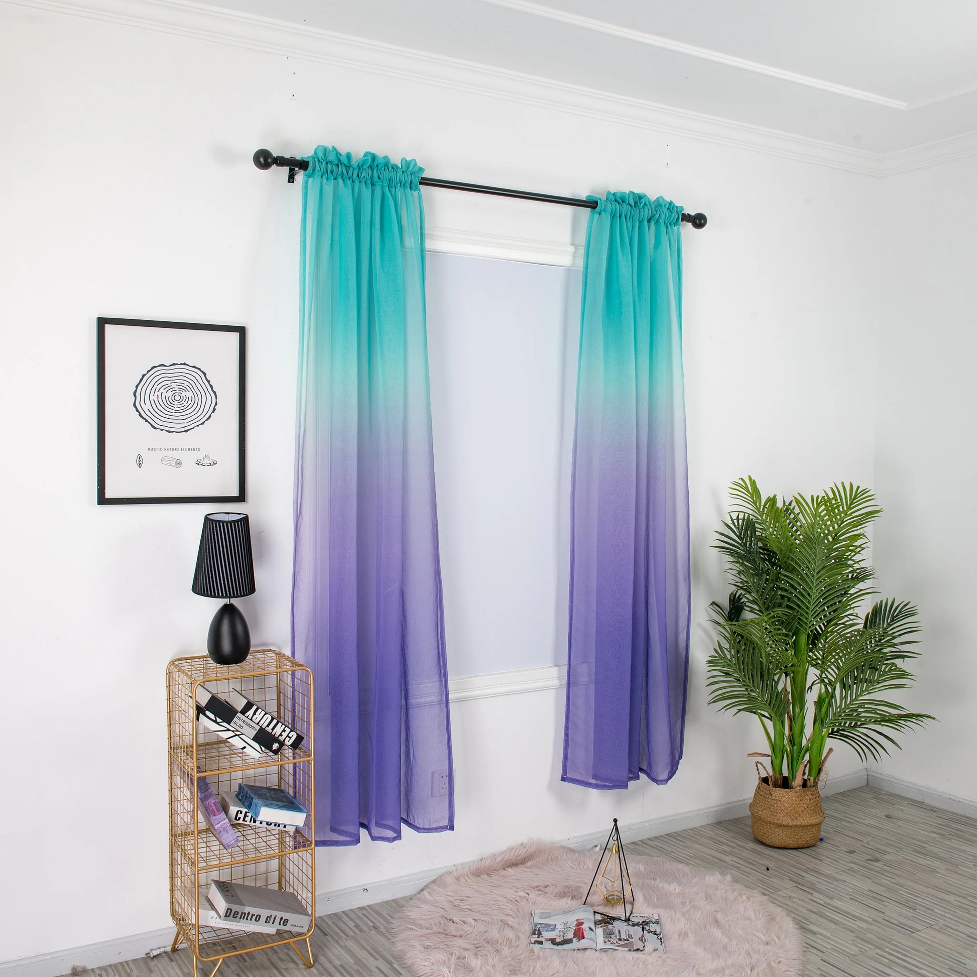 Voilage dégradé turquoise et violet installé sur une tringle noire dans une pièce lumineuse avec déco végétale.