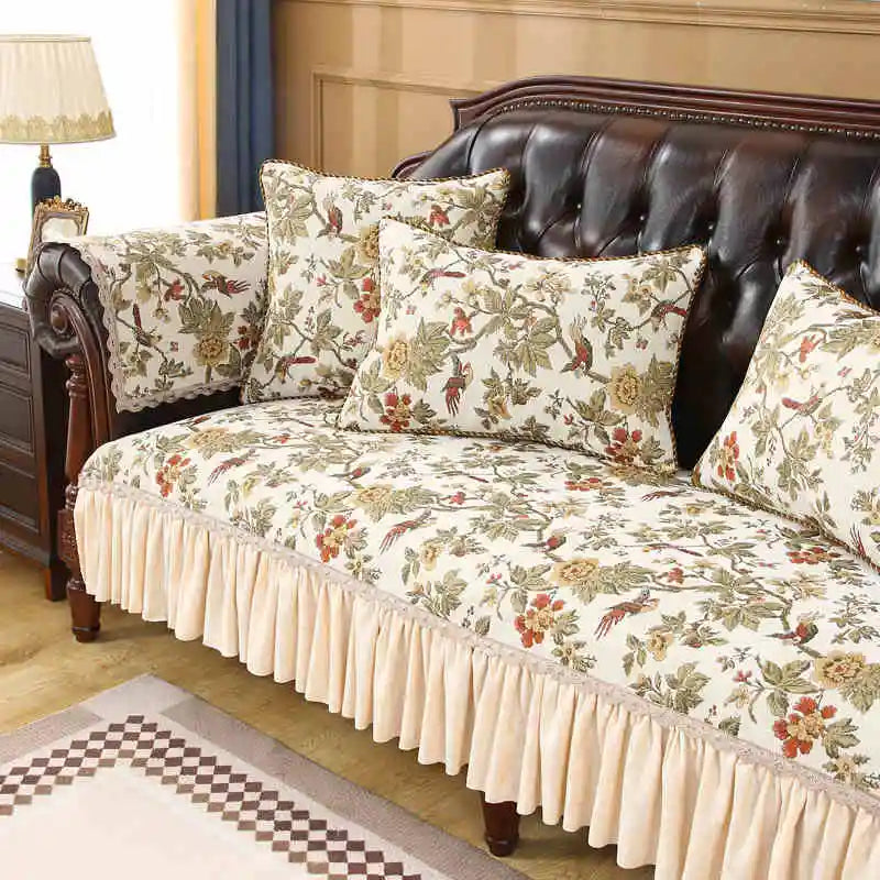 Un canapé en cuir brun avec des oreillers et une housse de style floral vintage, dans un décor élégant et chaleureux.