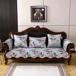 Un canapé vintage en bois sombre avec des coussins floraux raffinés, encadré par une œuvre d'art abstraite sur le mur, créant une ambiance élégante et sophistiquée dans cette pièce.