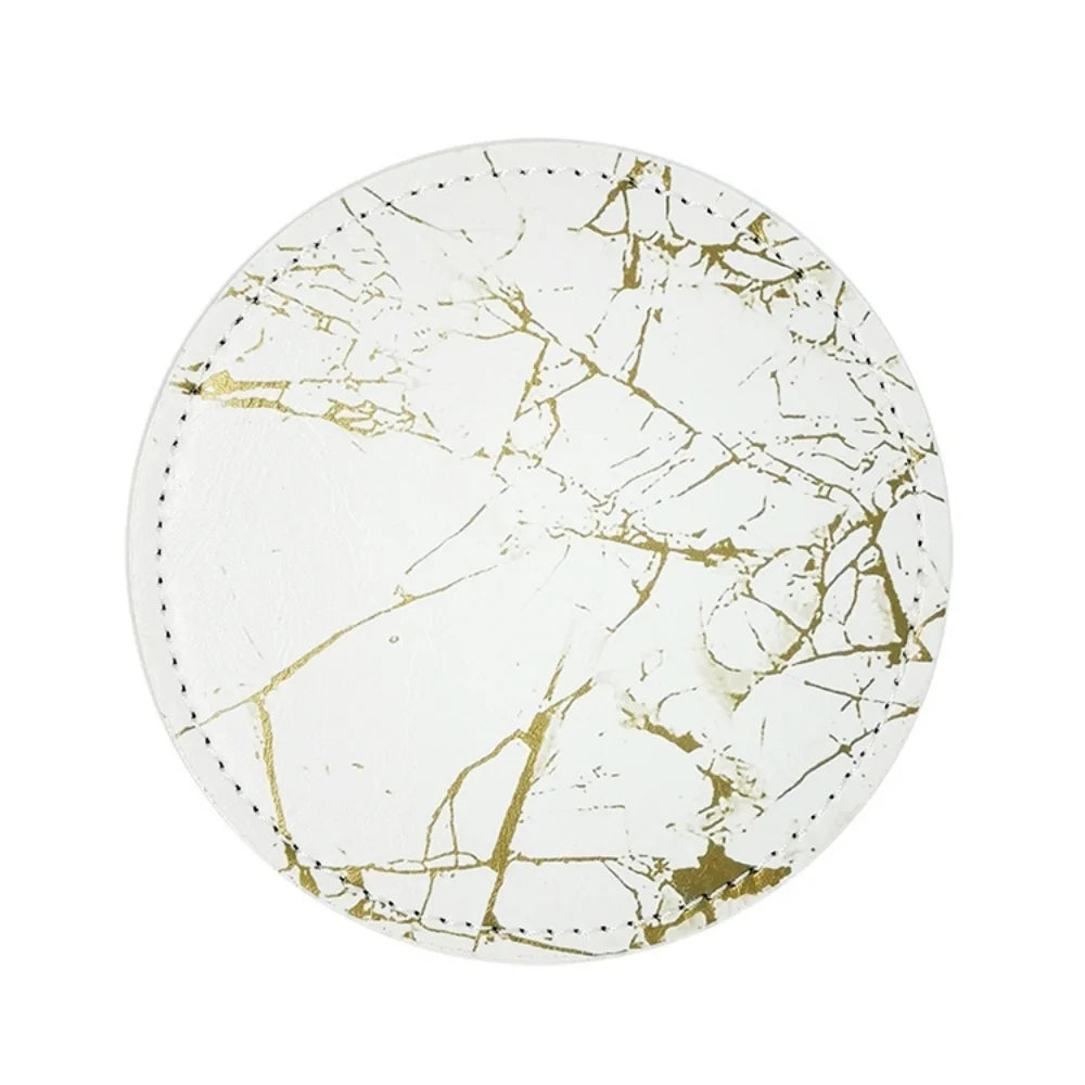 Assiette ronde en marbre blanc et or avec des motifs de veinures dorées, reflet d'un style élégant et épuré.