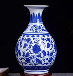 Vase en porcelaine bleue et blanche avec un motif floral élégant sur un fond sombre.