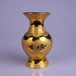 Cette image montre un vase décoratif doré avec des motifs complexes et une forme unique.