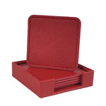 Une boîte en cuir rouge avec un couvercle et des dessous de verre carrés assortis.