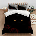 Un lit avec des taies d'oreiller noires et un couvre-lit décoré d'un chat noir aux yeux brillants et de roses rouges.