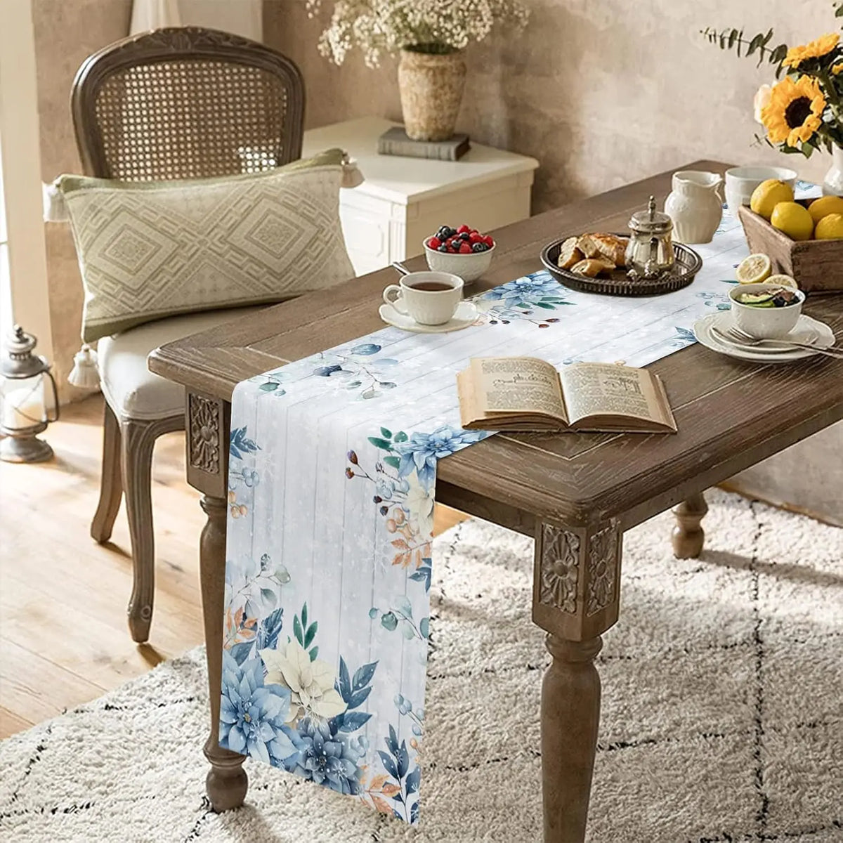 Table basse en bois vintage avec décoration florale bleue, tasse de thé, livre ouvert et plateau de fruits sur un tapis moelleux dans un intérieur cosy et élégant.