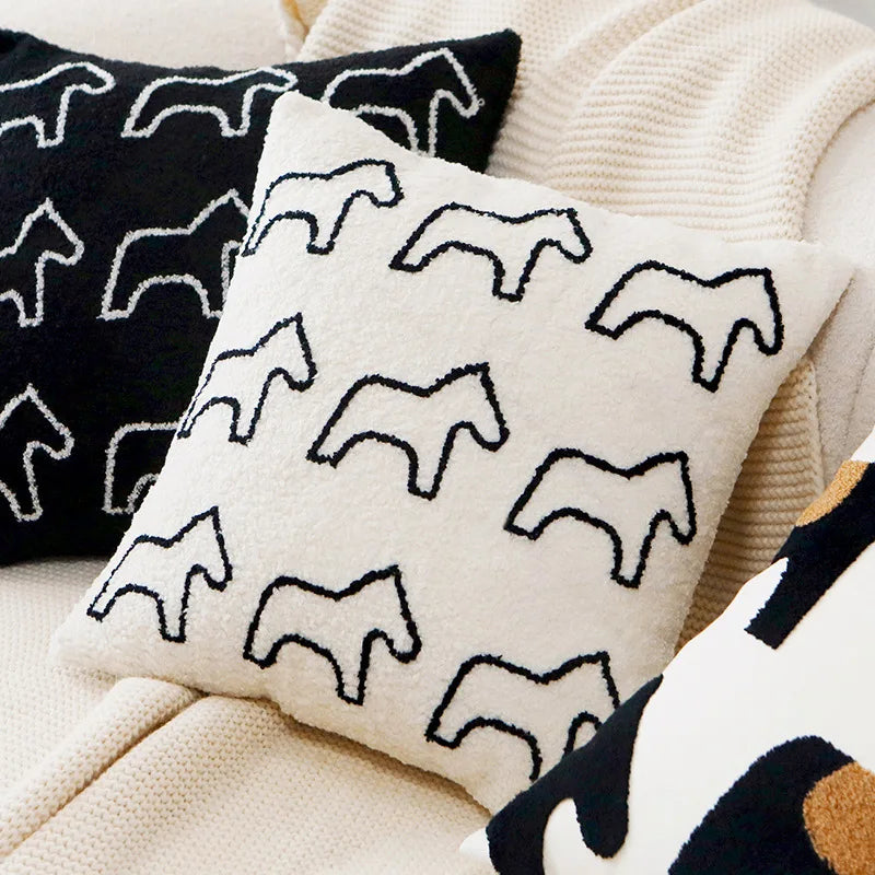 Coussin décoratif en noir et blanc avec un motif géométrique de silhouettes d'animaux, parfait pour ajouter une touche graphique à un espace intérieur.