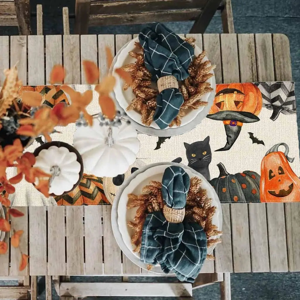 Une scène d'automne festive avec des éléments décoratifs orange et noir, incluant des citrouilles, des chauves-souris et un chat noir.