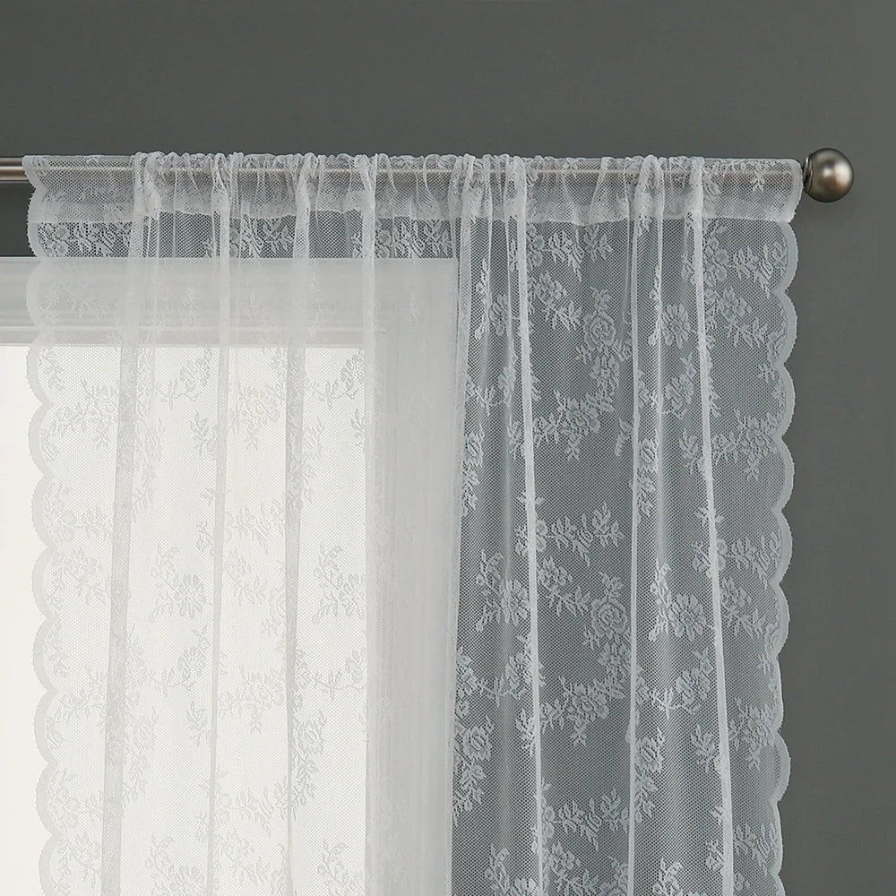 Voilage blanc transparent à motifs floraux, suspendu sur une tringle métallique.
