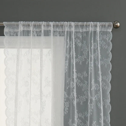 Voilage blanc transparent à motifs floraux, suspendu sur une tringle métallique.