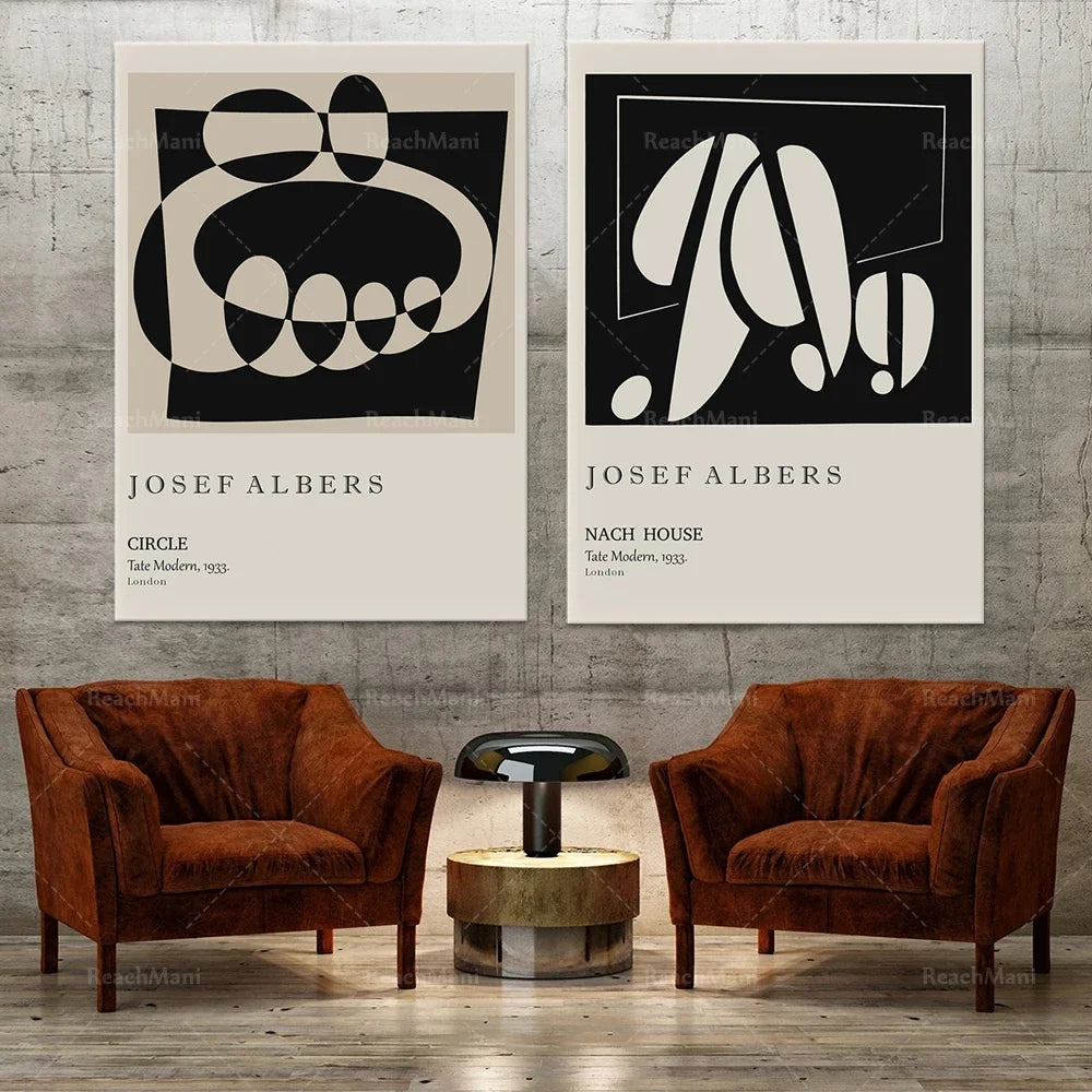 Deux affiches minimalistes en noir et blanc encadrent deux fauteuils en velours marron, créant une ambiance contemporaine et élégante.