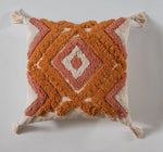 Coussin décoratif avec un motif géométrique en tons oranges et roses sur un fond beige.