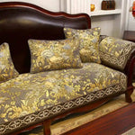 Un canapé vintage en bois foncé avec des coussins dorés et motifs floraux, placé dans un intérieur élégant avec des éléments décoratifs.