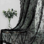 Détail du motif floral en dentelle noire du rideau