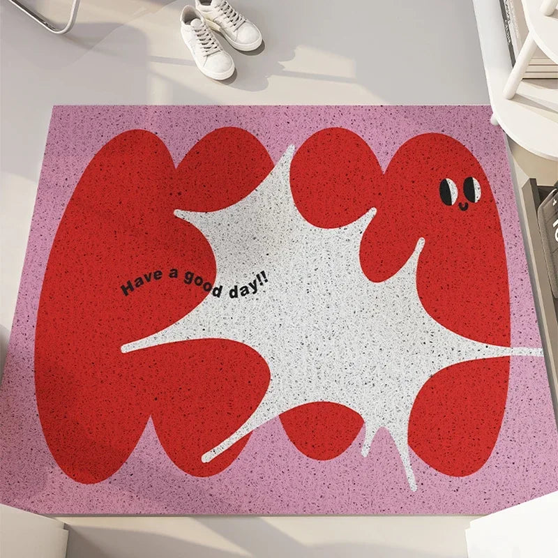Tapis décoratif rose et rouge avec motif de personnages aux formes organiques et le texte "Have a good day!!" en son centre.