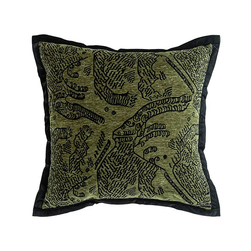 Coussin décoratif orné d'un motif abstrait noir et vert.