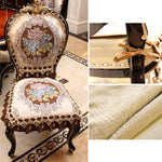 Chaise ornée de motifs floraux et dorés, avec des accents décoratifs en métal, posée sur un sol de marbre.