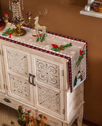 Mobilier de Noël décoré avec des motifs floraux sculptés, des figurines de renne et des éléments décoratifs festifs sur un meuble vintage.