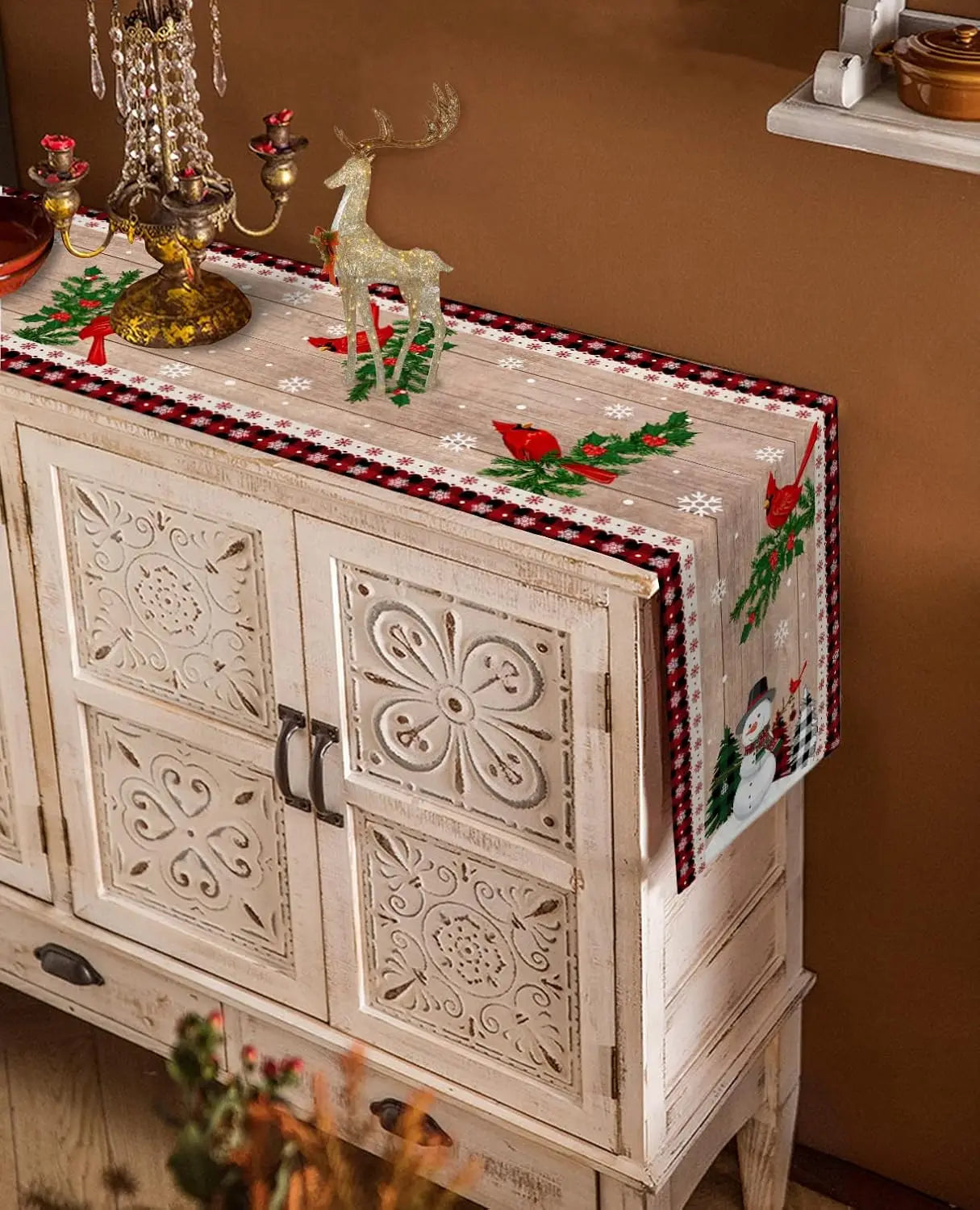 Mobilier de Noël décoré avec des motifs floraux sculptés, des figurines de renne et des éléments décoratifs festifs sur un meuble vintage.