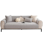 Un élégant canapé gris matelassé avec un oreiller en forme de nœud et d'autres accessoires décoratifs, créant une atmosphère chaleureuse et confortable dans un intérieur contemporain.