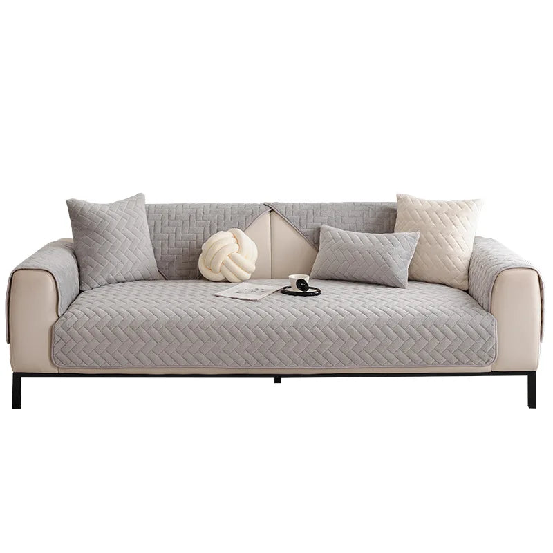 Un élégant canapé gris matelassé avec un oreiller en forme de nœud et d'autres accessoires décoratifs, créant une atmosphère chaleureuse et confortable dans un intérieur contemporain.