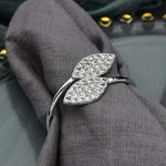 Un bracelet décoratif orné de cristaux brillants, enroulé autour d'un tissu gris.