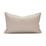 Coussin décoratif beige avec un motif géométrique discret.