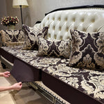 Un canapé en cuir blanc capitonné décoré de coussins aux motifs floraux sombres et élégants, une magnifique scène d'intérieur chic et raffinée.