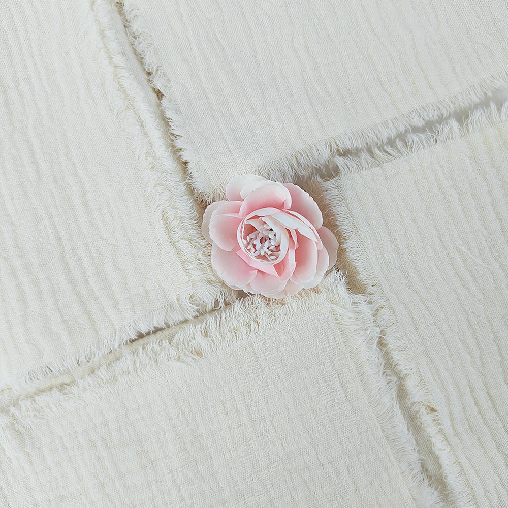 Une délicate fleur rose posée sur un textile doux et moelleux.