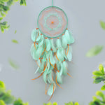 Attrape-rêves suspendu avec des plumes douces et des perles colorées, créant une décoration élégante et apaisante.