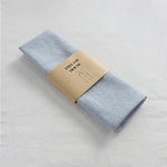 serviettes tissu pliées rustique bohème minimaliste liens anneaux couleurs beige rose vert bleu gris
