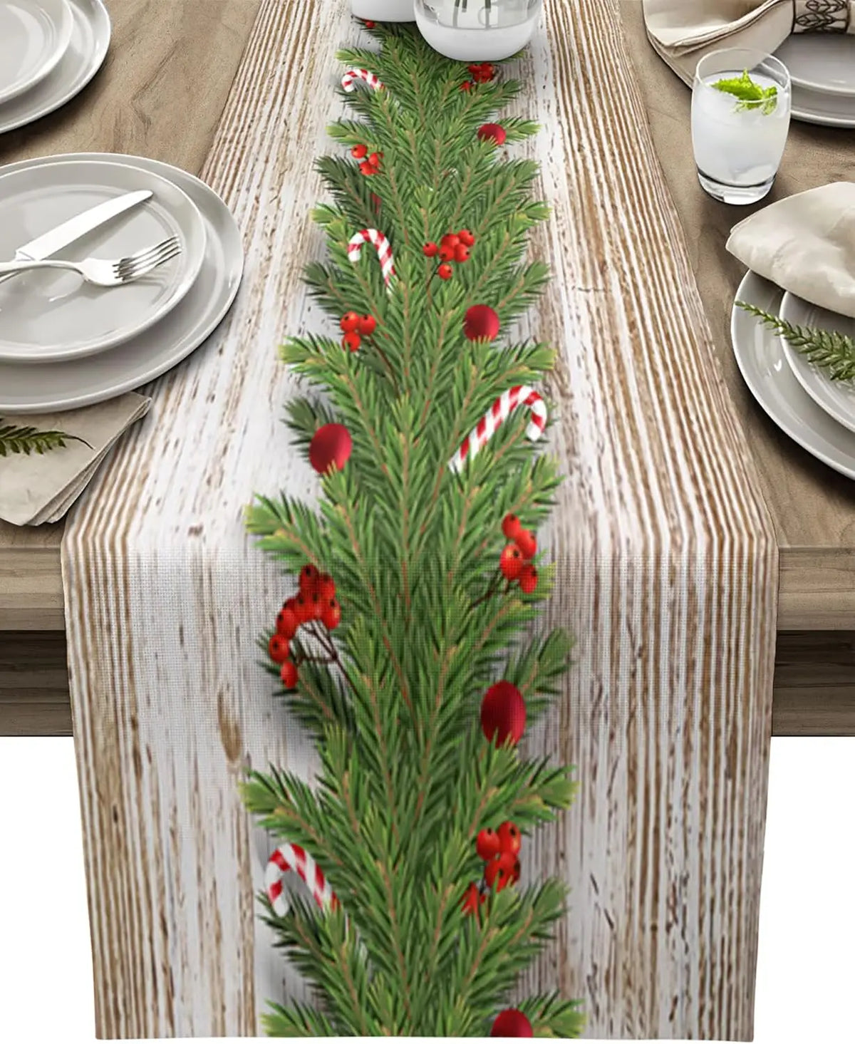 Cette image montre un chemin de table en bois décoré de branches de sapin, de baies rouges et de cannes en bonbon, créant une ambiance festive et chaleureuse.