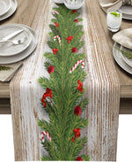 Cette image montre un chemin de table en bois décoré de branches de sapin, de baies rouges et de cannes en bonbon, créant une ambiance festive et chaleureuse.