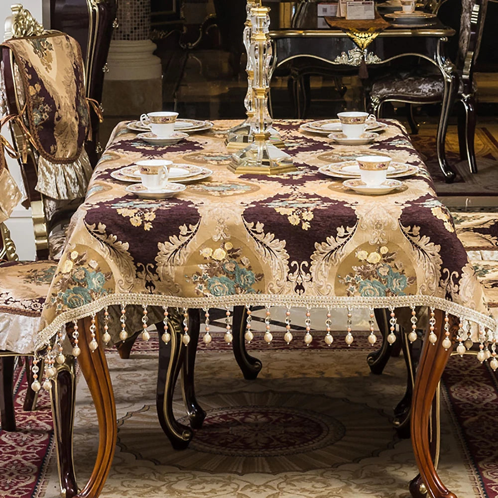 La table à dîner au design ornementé, avec ses assiettes, tasses et chandelier dorés, évoque une atmosphère luxueuse et raffinée.