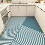 Un carrelage de sol moderne avec des rayures géométriques en bleu et blanc, dans une cuisine à l'allure épurée et lumineuse.