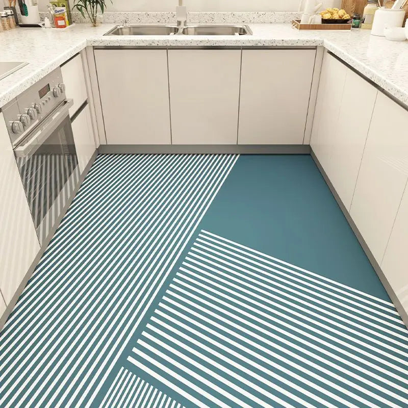 Un carrelage de sol moderne avec des rayures géométriques en bleu et blanc, dans une cuisine à l'allure épurée et lumineuse.