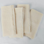 Serviettes de bain beige en tissu texturé et doux.